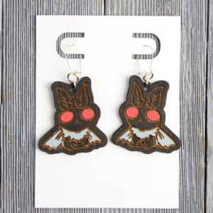 Mothman Wood Earrings. These earrings are made with 1/8″ thickness basswood. These earrings are lightweight and hand painted.