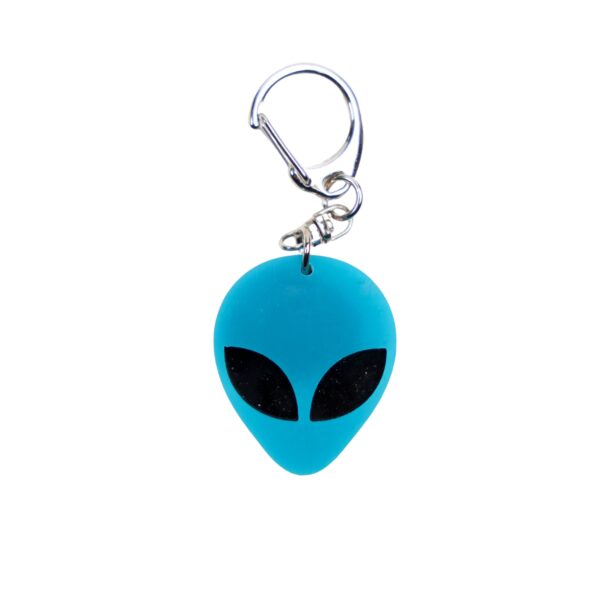 Alien head neon blue bag tag with black eyes and black backing.