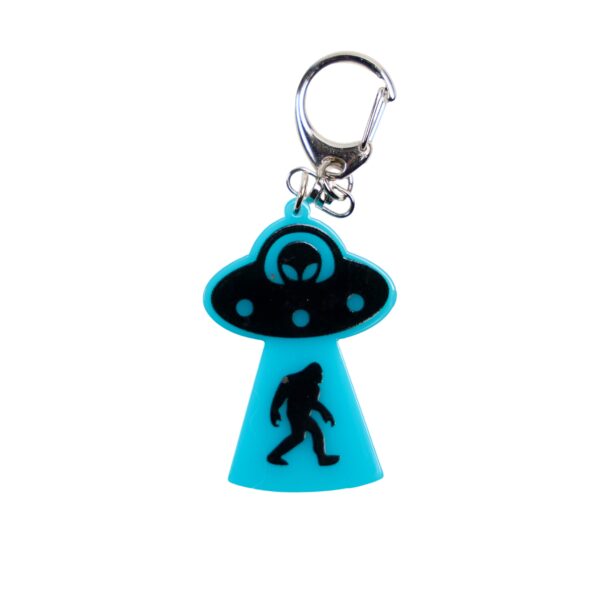 Bigfoot abduction neon blue bag tag with black ship and black backing.