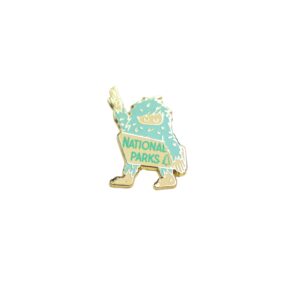 Bigfoot national parks enamel pin in green and white with bigfoot holding up a peace sign.