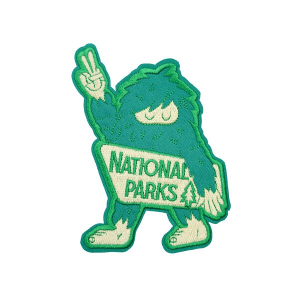 Bigfoot National Parks patch with green and white bigfoot holding up the peace sign.