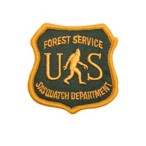 Forest service sasquatch department patch with a bigfoot on it and US in green and yellow.